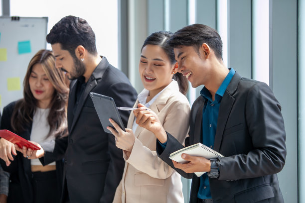 业务团队男女同事在工作中交谈，手中拿着数据报告，分享想法，快乐的同事在办公室一起工作。图片下载