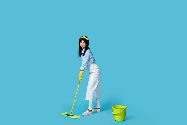妇女戴橡胶手套和清洁围裙与清洁用品图片下载
