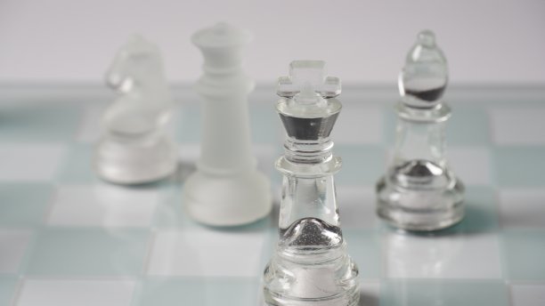 透明的国际象棋棋子，在反射棋盘上的起始位置，红色调。战略国际象棋棋盘游戏图片下载