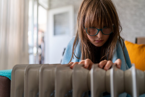 小女孩检查加热器温度散热器特写图片下载