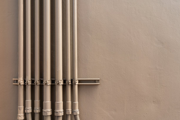 棕色的水管在棕色的墙上。图片下载