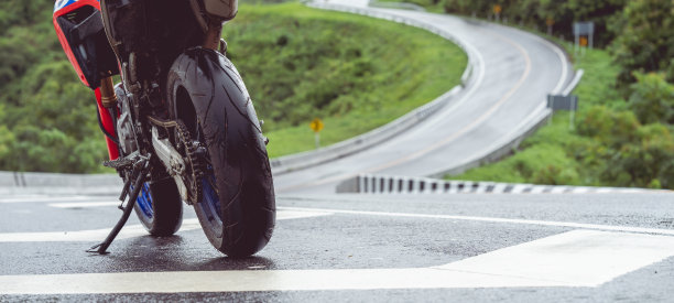 摩托车在阳光明媚的路上骑摩托车。与夕阳的光。单独文本的复制空间。摩托车胜利。图片下载