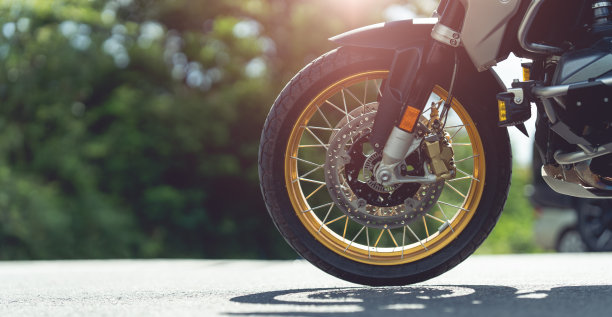 摩托车在阳光明媚的路上骑摩托车。与夕阳的光。单独文本的复制空间。摩托车胜利。图片下载