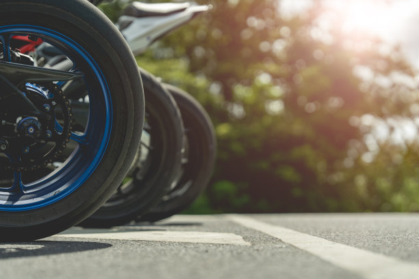 摩托车在阳光明媚的路上骑摩托车。与夕阳的光。单独文本的复制空间。摩托车胜利。图片下载