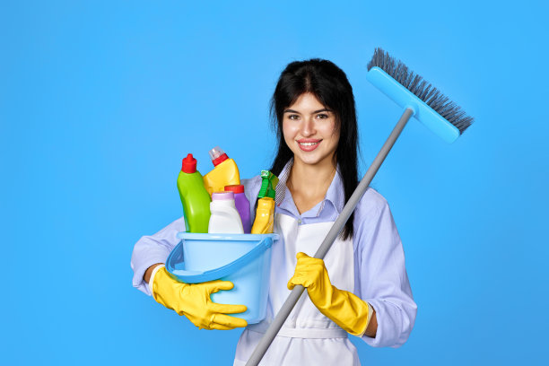 戴着手套的女人拿着一桶清洁剂和扫帚图片下载
