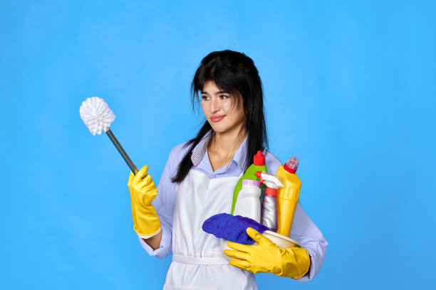 戴着手套的女人拿着一桶清洁剂图片下载