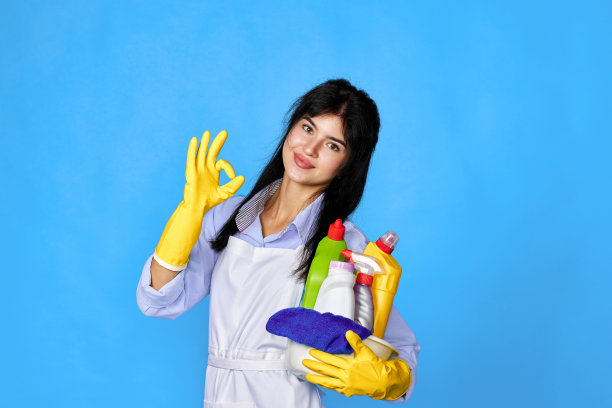 戴手套的妇女拿着一桶清洁剂，摆出Ok的姿势图片下载