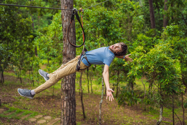 年轻迷人的男子在冒险绳索公园的安全设备图片下载
