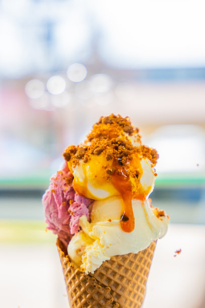 不同口味的冰淇淋蛋筒，勺子上撒着面包屑图片下载