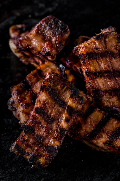 用樱桃酱腌制的烤排骨。排骨放在深色的木制背景上。特写镜头图片下载