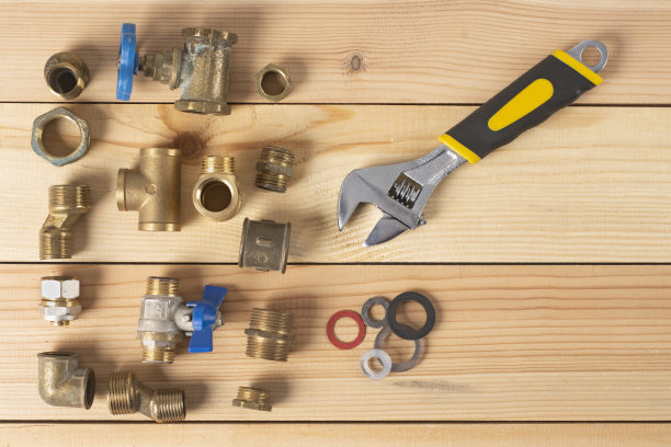 金属管道三通，水管适配器放在木桌上。图片下载