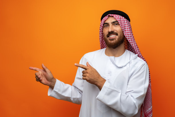 年轻的阿拉伯男子用手在橙色背景上复制空间图片下载