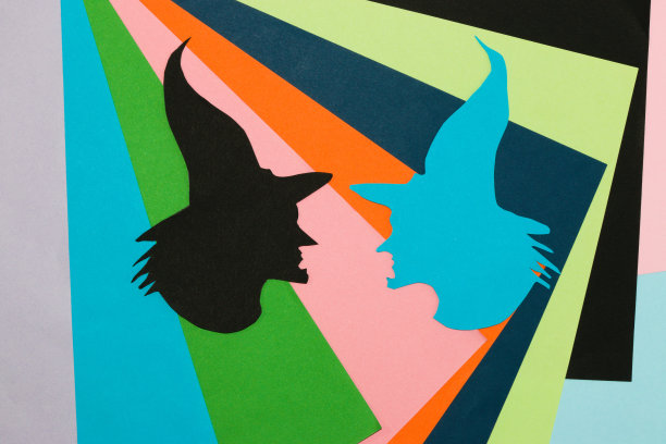 彩色背景上的两个女巫头，创意艺术设计，万圣节概念，平铺，纸工艺品图片下载