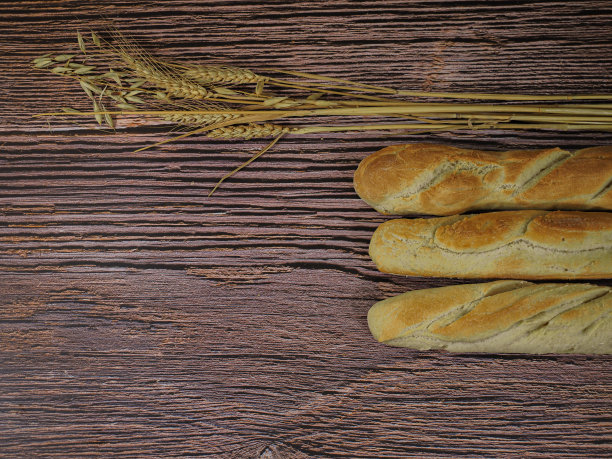 自制的法式面包在木制背景和小麦和燕麦装饰。空间写图片下载