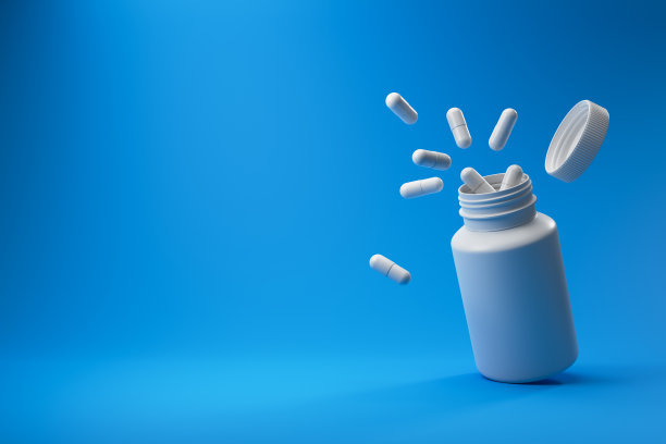 蓝色背景的白色药片和塑料医疗容器。图片下载