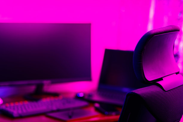 创意设计师的工作场所，后景。办公椅和工作台视图与图形平板电脑，电脑和智能手机。修图师的家庭办公室在霓虹粉蓝色图片下载