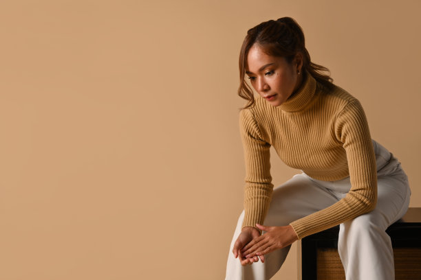 美丽的时尚女子在秋季服装摆姿势在米色背景。时尚工作室照片，秋季时尚与美的概念。图片下载