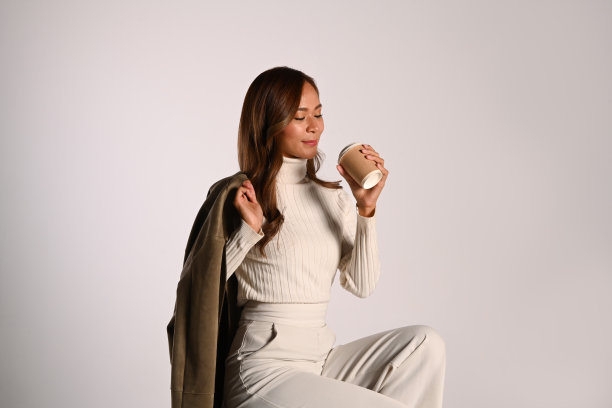 美丽的时尚女子在秋季服装摆姿势在米色背景。时尚工作室照片，秋季时尚与美的概念。图片下载