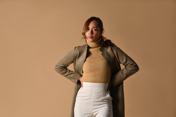 美丽的时尚女子在秋季服装摆姿势在米色背景。时尚工作室照片，秋季时尚与美的概念。图片下载