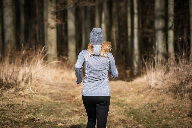 戴着针织帽的妇女在户外跑步图片下载
