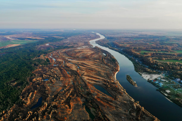 秋天无人机摄影。保护水和自然。池塘。湖。阳光明媚的一天。日落。地球上空飞行。自然背景。大气的格局。森林里的黄树。10月图片下载