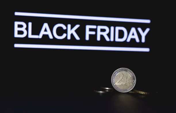 欧元硬币和黑色星期五的文字在黑暗的背景。全球黑色星期五大减价。这是网上零售商最忙的一天。欧元，金属货币。大促销，折扣，特别优惠。年度最佳销售图片下载