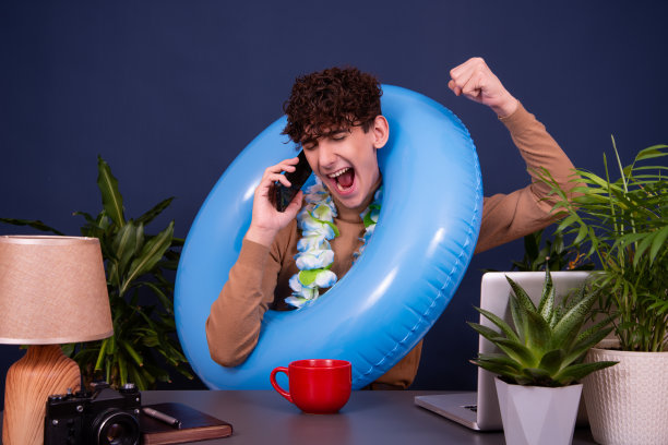 一个年轻有魅力的家伙在办公室工作，梦想着度假。图片下载