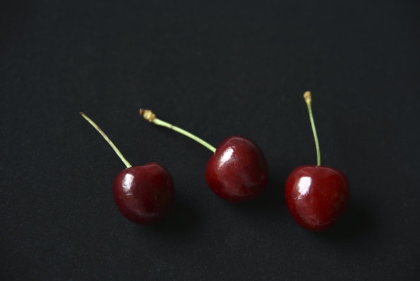 红色多汁樱桃浆果在黑色天鹅绒背景。图片下载