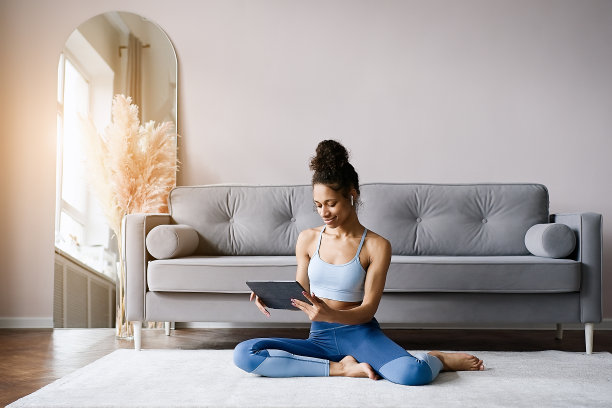 非裔美国妇女在客厅的瑜伽垫上训练图片下载