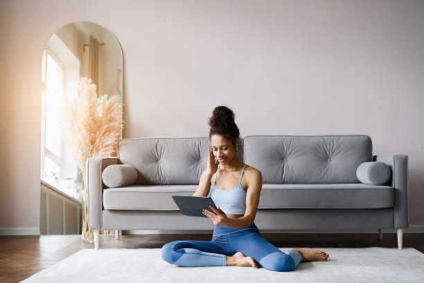 非裔美国妇女在客厅的瑜伽垫上训练图片下载