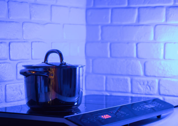 现代厨房电磁炉上的金属锅图片下载