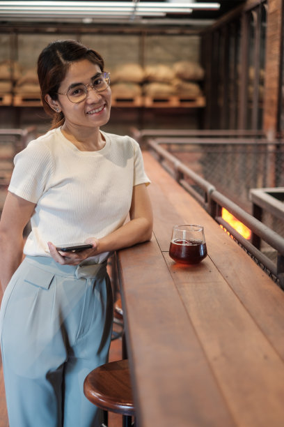 休闲女商人拿着并使用智能手机发短信，年轻女性在咖啡馆或现代办公室打字触屏手机。生活方式、技术、社交媒体和网络概念图片下载