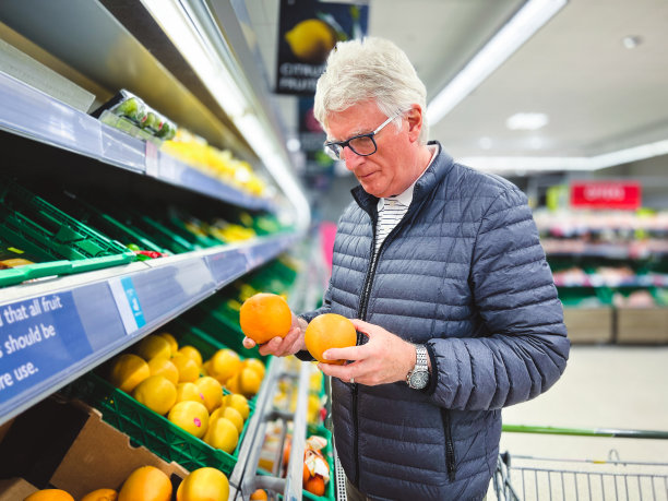 老人在超市里看柑橘类水果图片下载