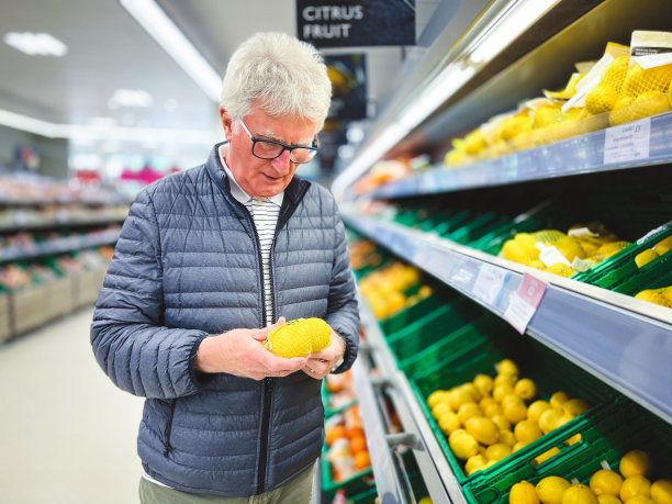 老人在超市里看柑橘类水果图片下载