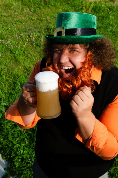 滑稽的胖子在街上喝啤酒。图片下载