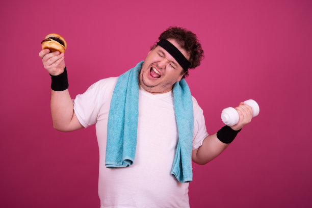 饮食、健身和健康的生活方式。有趣的胖子在吃汉堡。图片下载