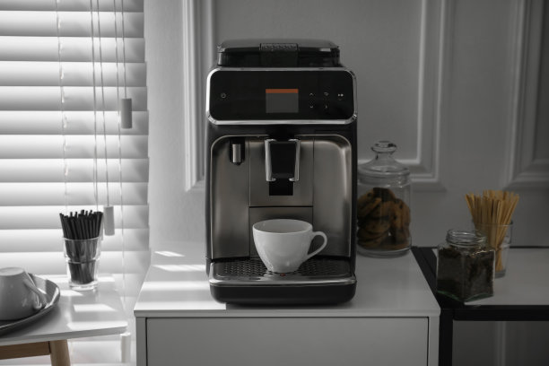 办公室里带杯子的现代咖啡机图片下载