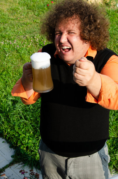 滑稽的胖子在街上喝啤酒。图片下载
