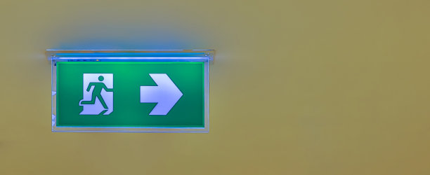 指示逃生路线的绿色紧急出口标志。大楼里的安全出口。图片下载
