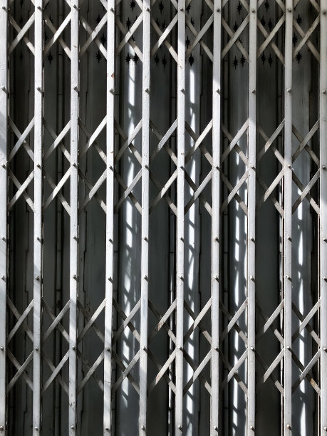 传统的2层剪刀和折叠面板泰国中国铸造金属门风格在下午的阳光下灰色图片下载