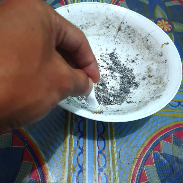 有人的手正在熄灭烟灰缸里的香烟图片下载