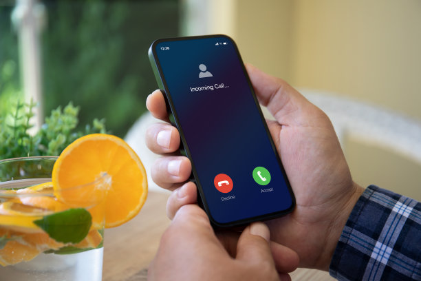 男子手持电话，来电显示在屏幕上图片下载