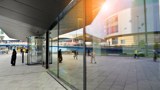 办公楼的玻璃窗和人行道。阳光反射在大玻璃板上。图片下载