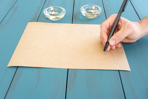 男人手里拿着自来水笔在一张牛皮纸上，准备签字。图片下载