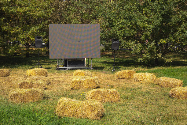 公园里没有观众的户外电影院，用干草捆代替座位，空白屏幕上有文字或标识的空间图片下载