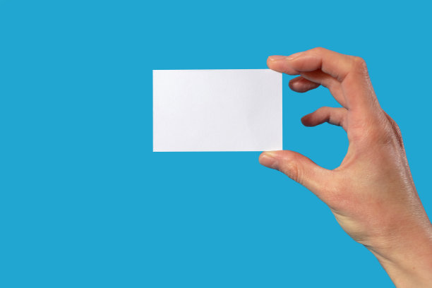 人手握一张蓝色背景的白纸，上面有空白的文字图片下载
