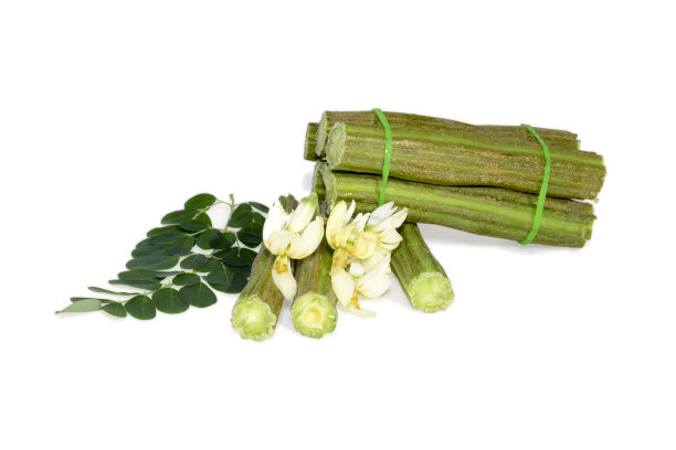 新鲜的生绿辣木豆和一块孤立的白色背景图片下载