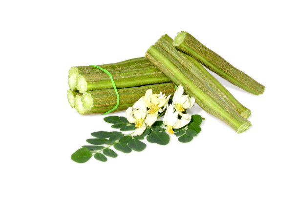 新鲜的生绿辣木豆和一块孤立的白色背景图片下载