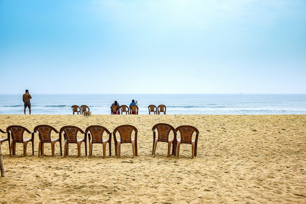 2020年2月，在印度奥里萨邦普里的海滨，一些人坐在海边海滩前的椅子上欣赏大海的景色。图片下载