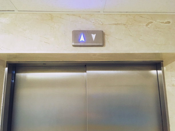 金属色电梯的上下箭头，向上箭头被照亮。图片下载